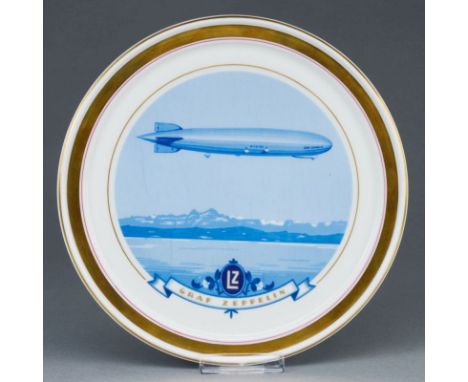 Wandteller Luftschiff Graf ZeppelinHeinrich &amp; Co., Selb 1929. Porzellan, weiß, glasiert. Polychrom dekoriert. Goldrand. U