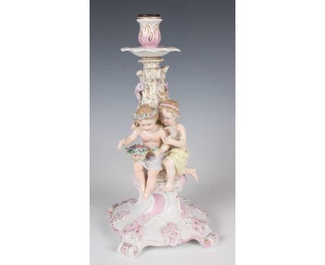 A Continental porcelain Meissen style candelabra, early 20th century, modelled with two putti before a scroll moulded gilt en