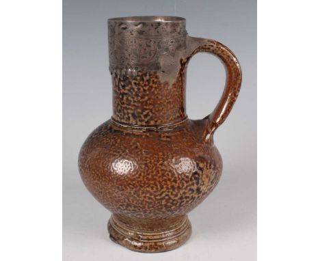 A silver mounted mottled tiger glaze stoneware jug, circa 1600, the bulbous body on a small flared foot beneath the narrow cy