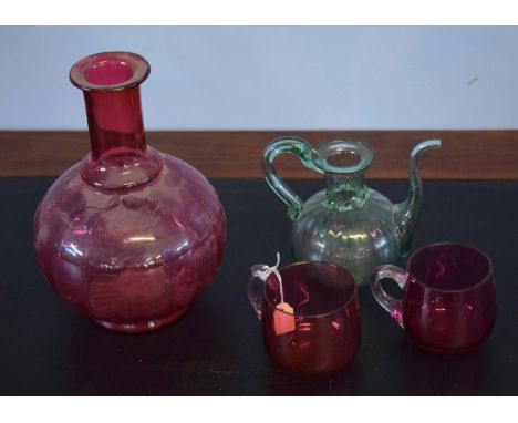 Group of four glass wares including a globular ruby decanter, two small cups and a further green ewer (4)    