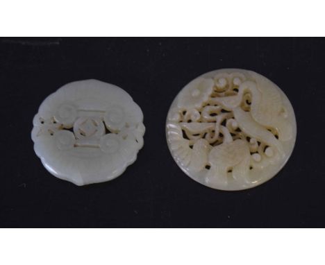 Two green jade medallions, one carved with birds, the other with a geometric design (2)    