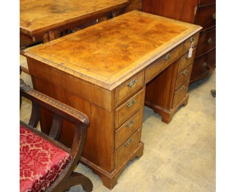 A George I style burr walnut pedestal desk, W.115cm, D.62cm, H.73cmCONDITION: The top is generally faded around the edge with