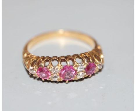 An early 20th century 18ct and graduated three stone ruby and diamond chip set half hoop ring, size M, gross 3.6 grams.CONDIT