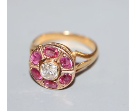 A late 19th/early 20th century yellow metal, ruby and diamond set circular cluster ring, size J, gross 3.8 grams.CONDITION: M