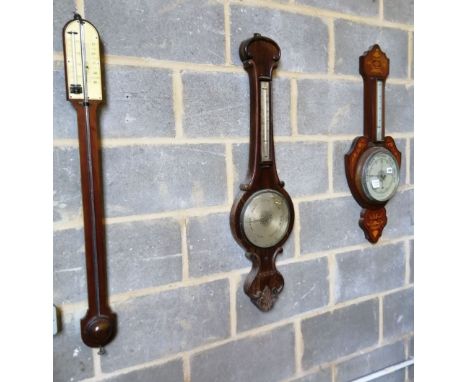 A Victorian rosewood wheel barometer, an Edwardian inlaid aneroid barometer and a stick barometer