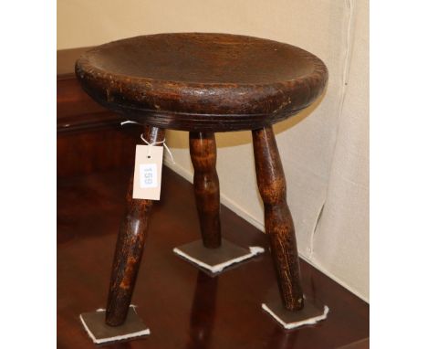 A round turned primitive pine stool with dish top, c.1840, 33cm diameter, H.36cm