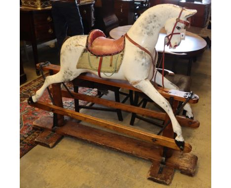 An early 20th century Ayres type carved wood dapple grey rocking horse on pine safety frame, H.130cm, L.160cmCONDITION: Lacki