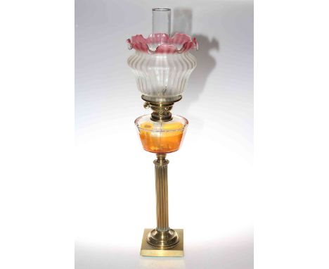 Brass reeded column oil lamp with clear glass reservoir and ruby tinted etched shade