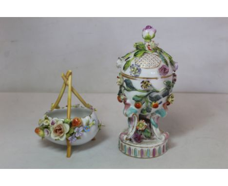 Continental porcelain pot pourri vase of ovoid form on three scroll supports and circular plinth base with polychrome floral 