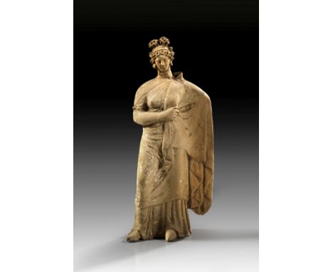 Frau im Mantel. Magna Graecia, 4. Jh. v. Chr. H 25,4cm. Hellbrauner, leicht grünlicher Ton, geringe Reste weißer Engobe. Matr