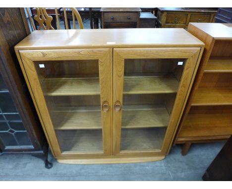 An Ercol Blonde elm two door bookcase 