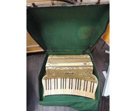 A vintage Hohner piano accordion of cream celluloid fretwork design in original case