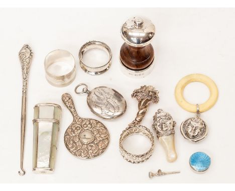 A collection of assorted silverware comprising: three napkin rings, miniature hand mirror, babies rattle, travellers set, ena