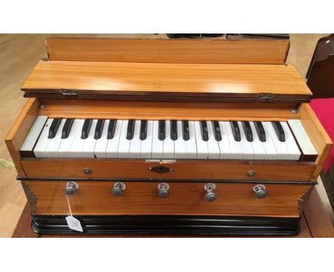 An early 20th Century Harmonium, fitted in a wood grained case, having three octaves, 26cm high, 55cm wide, 30cm deep