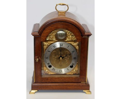 An Elliott eight day mahogany cased mantle clock, arched case, silvered chapter dial, reading 'Tempus Fugit', raised on brack