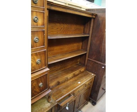 An 18th Century style joined oak dresser and rack, of recent manufacture, traditionally made, the rack with three fitted shel