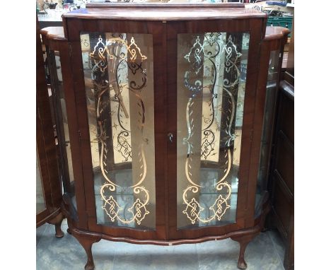 An Art Deco walnut demilune cabinet fitted with two doors, with containing glass shelves, 130cm high, 91cm wide, 32cm deep, t