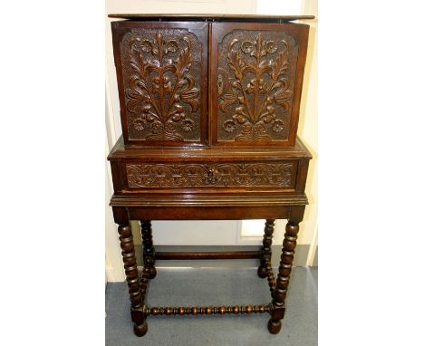 A 19th Century collectors cabinet on stand, the two doors enclosing multiple drawers and a central cupboard, all drawer front