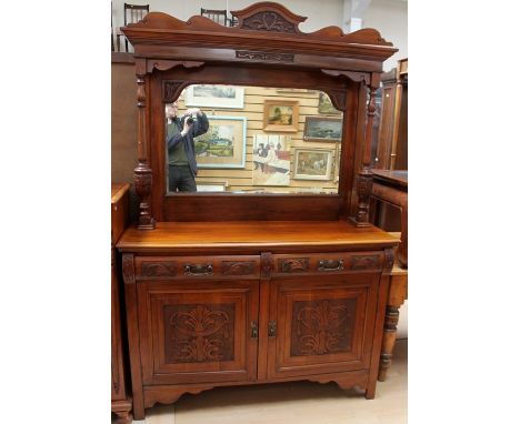 A late Victorian walnut mirror backed sideboard, the top with a carved pediment and moulded cornice, turned column supports w