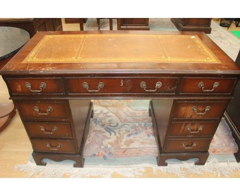 A traditional mahogany twin pedestal desk, of recent manufacture, the top with inset leather surface, gilt tooled border, thr