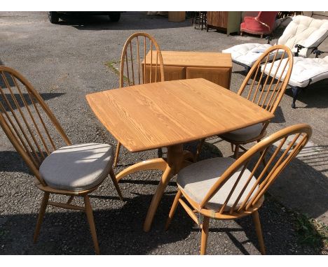 An Ercol Windsor light elm and ash dining suite, comprising four stick back chairs, with elm seats and an extending dining ta