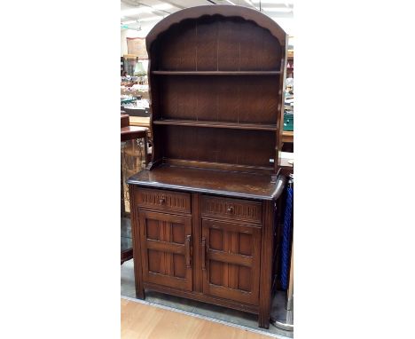A Jacobean style oak dresser and rack, of recent manufacture, the rack with two plate shelves, the base with two drawers over