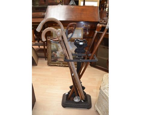 Circa late 19th Century cast iron stick stand with 20th Century walking sticks, Empire style