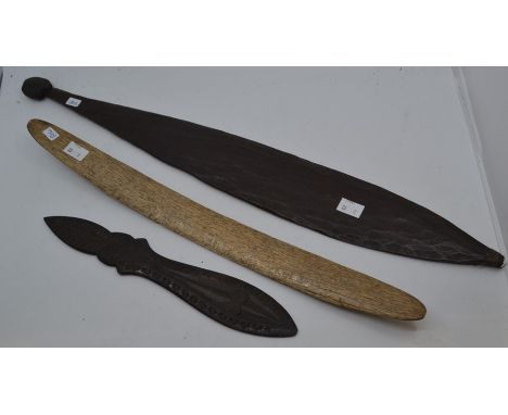 Three 19th Century tribal artefacts comprising a wooden paddle, a decorated hardwood item and a bone tool, possibly for chopp