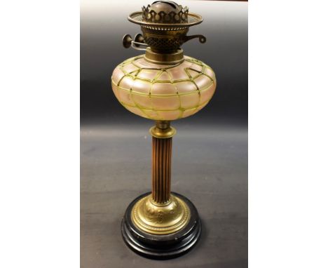 An early 20th century brass oil lamp, Loetz style glass reservoir, the base cast with scrolling leaves, Duplex twin burner