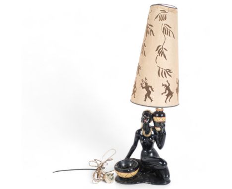 A painted plaster table lamp in the form of a Nubian style female figure, with associated shade, overall height approx 86cm 