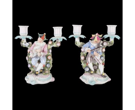 A pair of unusual German candelabra, with jester figures playing a cat and pig as musical instruments, H21cm 