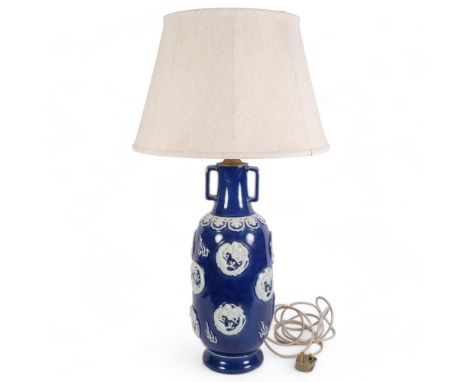 An Oriental ceramic blue and white table lamp, with embossed decoration and shade, H82cm 
