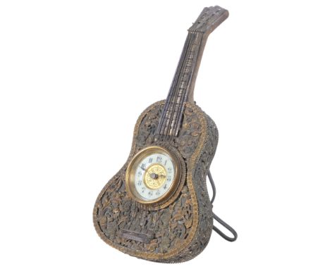 Vintage miniature clock set in a guitar design frame, with pierced and gilt-metal scrolled floral decoration, and strut suppo