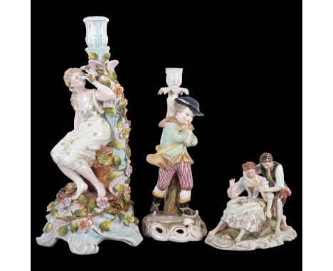 A German porcelain candlestick, supported by a girl smelling a flower, H35cm, a candlestick supported by a skater figure, bea