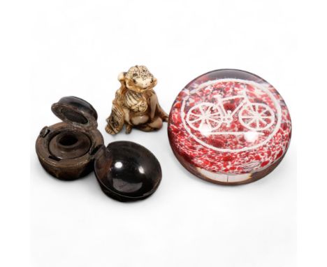 A French glass paperweight, with bicycle motif, a travelling metal inkwell, and a carved staghorn netsuke (3) 