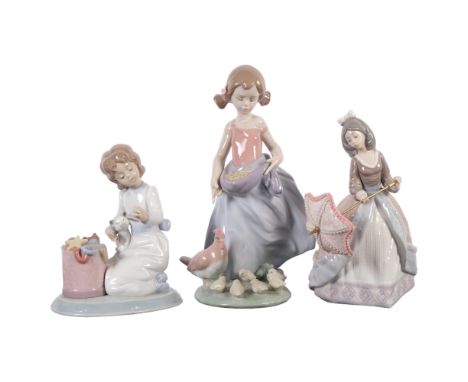 Lladro, girl feeding chickens, H24cm, and a Lladro Christmas Collection girl with kitten 