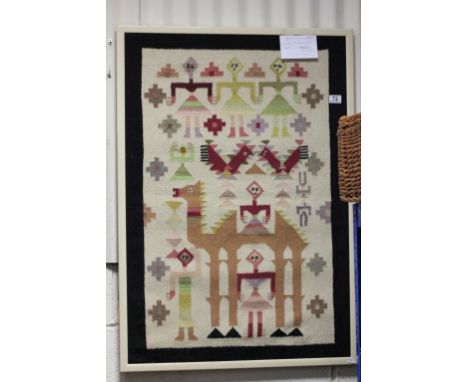 A framed original Tunisian tapestry of camel and figures, gallery label and seal to verso