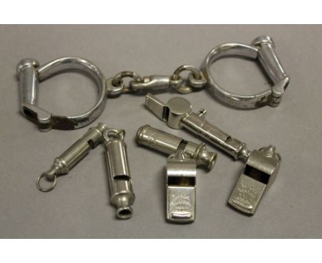 Vintage police handcuffs and six vintage whistles
