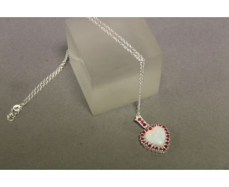 A silver ruby and heart shaped opal necklace on silver chain