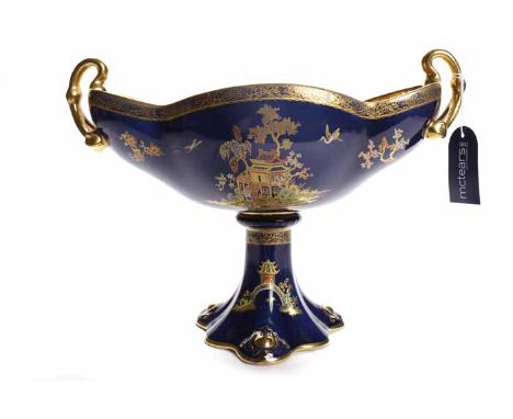 CARLTONWARE CHINOISERIE COMPORT
of boat form with twin handles on a trefoil plinth base, royal blue ground with chinoiserie m