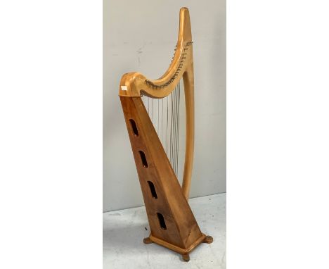 A freestanding lacquered beech and pine harp, fully strung and raised on four shaped feet, each carved with a star, 140cm tal