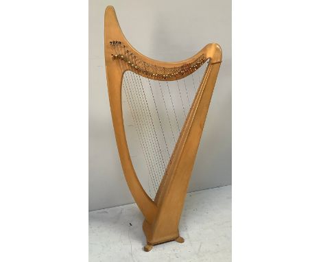 A freestanding beech and pine harp, some strings missing, raised on four shaped feet, 151cm tall 