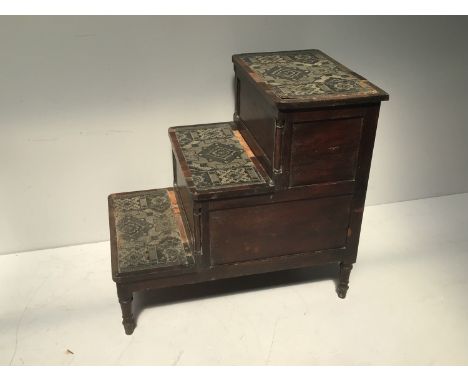 A set of George III stained oak bed steps, the three steps each inset with decorative coated hessian and cross banding, each 