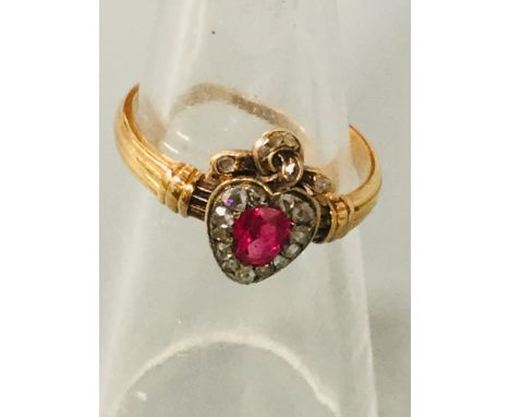 An 18ct gold heart shaped cluster ring set with a central oval cut ruby and nineteen rose cut diamonds, Circa 1890, finger si