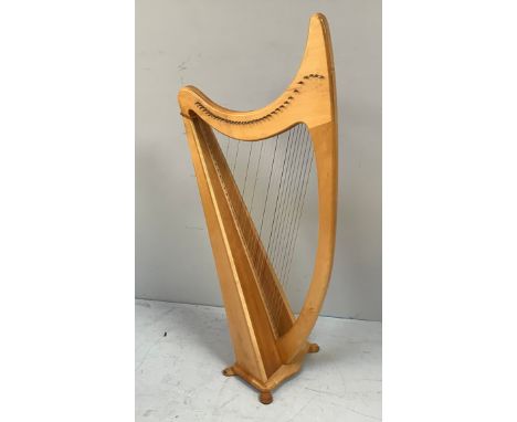 A freestanding lacquered beech and pine harp, fully strung and raised on four shaped feet, 140cm tall 