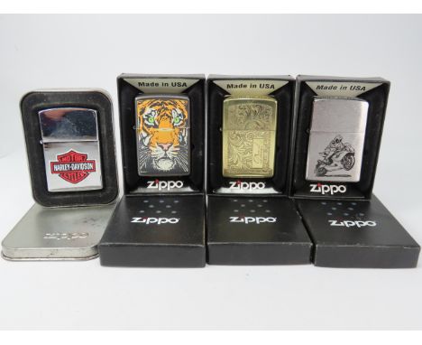 Four boxed Zippo lighters.