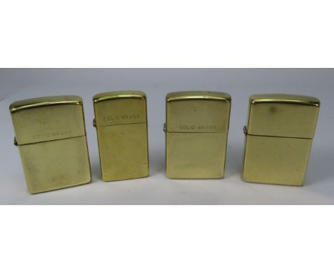 Four solid brass Zippo lighters.