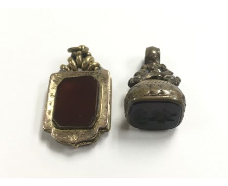 An intaglio seal carved with a portrait alongside a locket.
