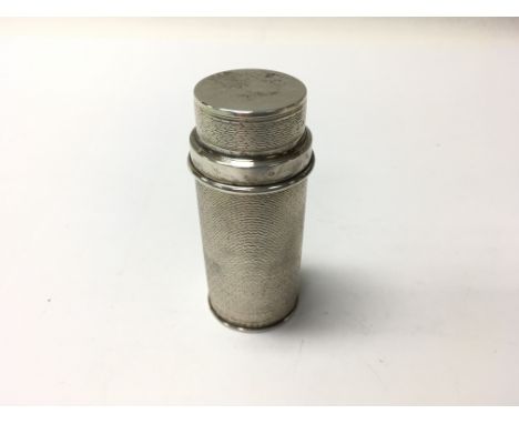 A silver engine turned sweetener dispenser.