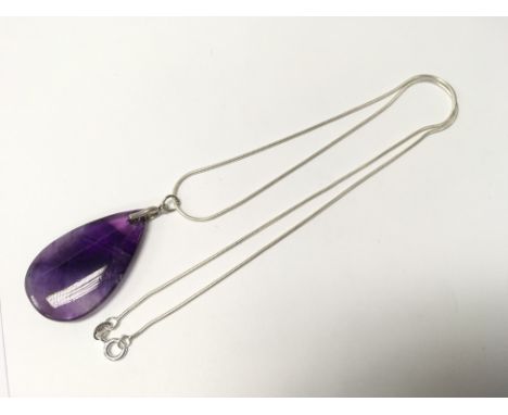 An amethyst pendant on silver chain.